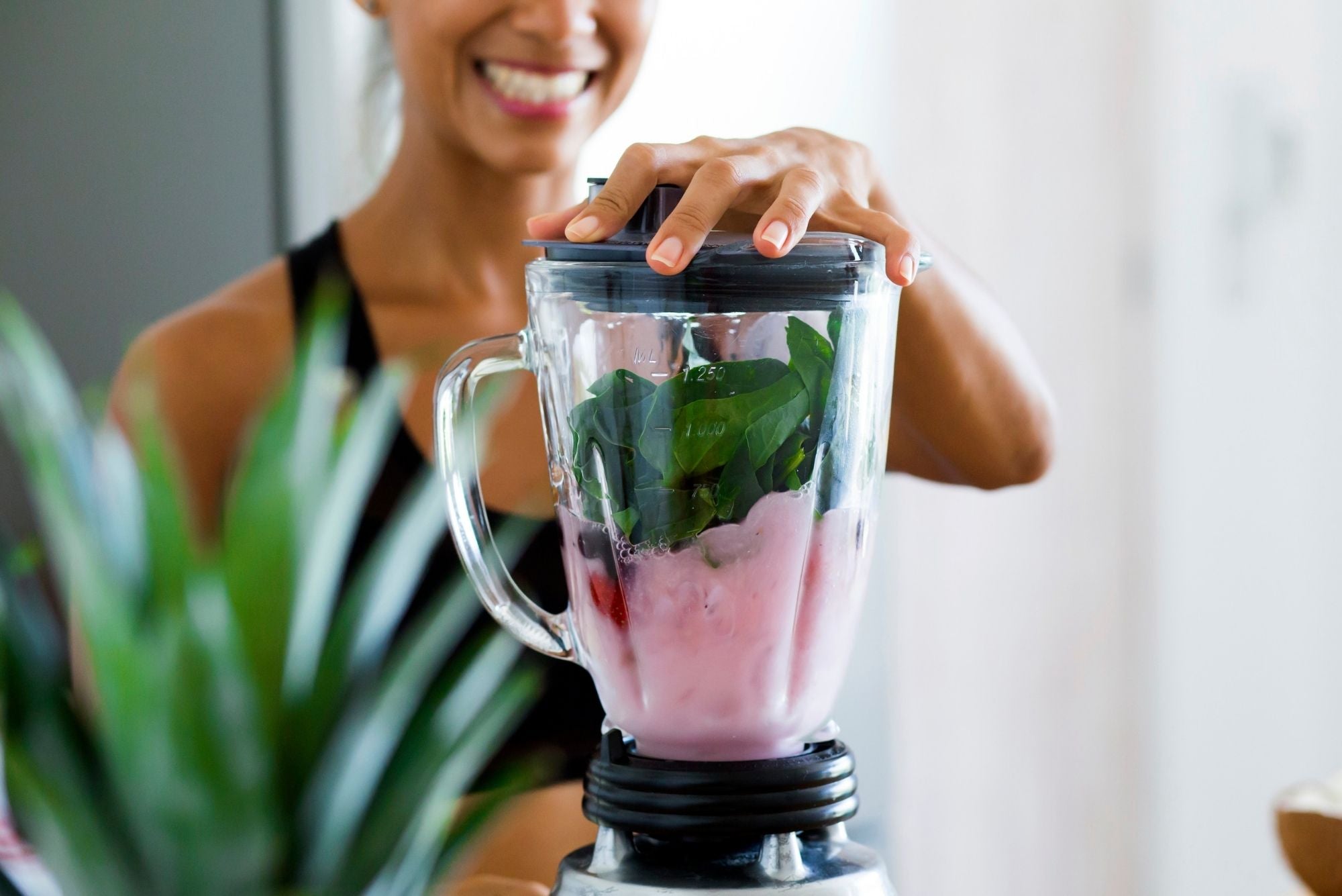 A woman making a smoothie out of foods that help heal cold sores.